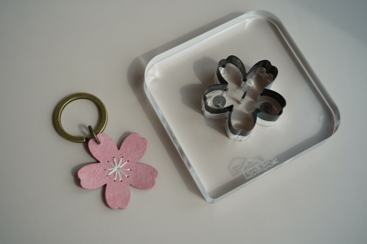 A die and the leather keyring it cut